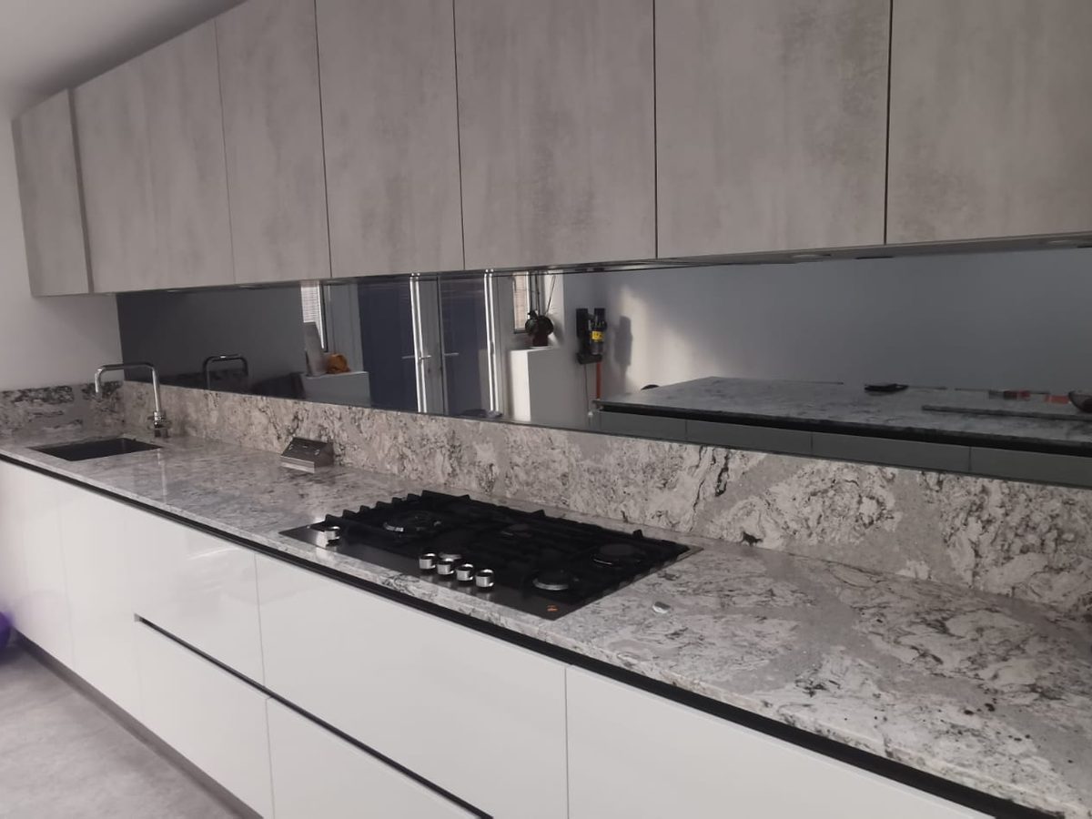 Mirrored glass splashback fitted behind a hob in an Essex kitchen