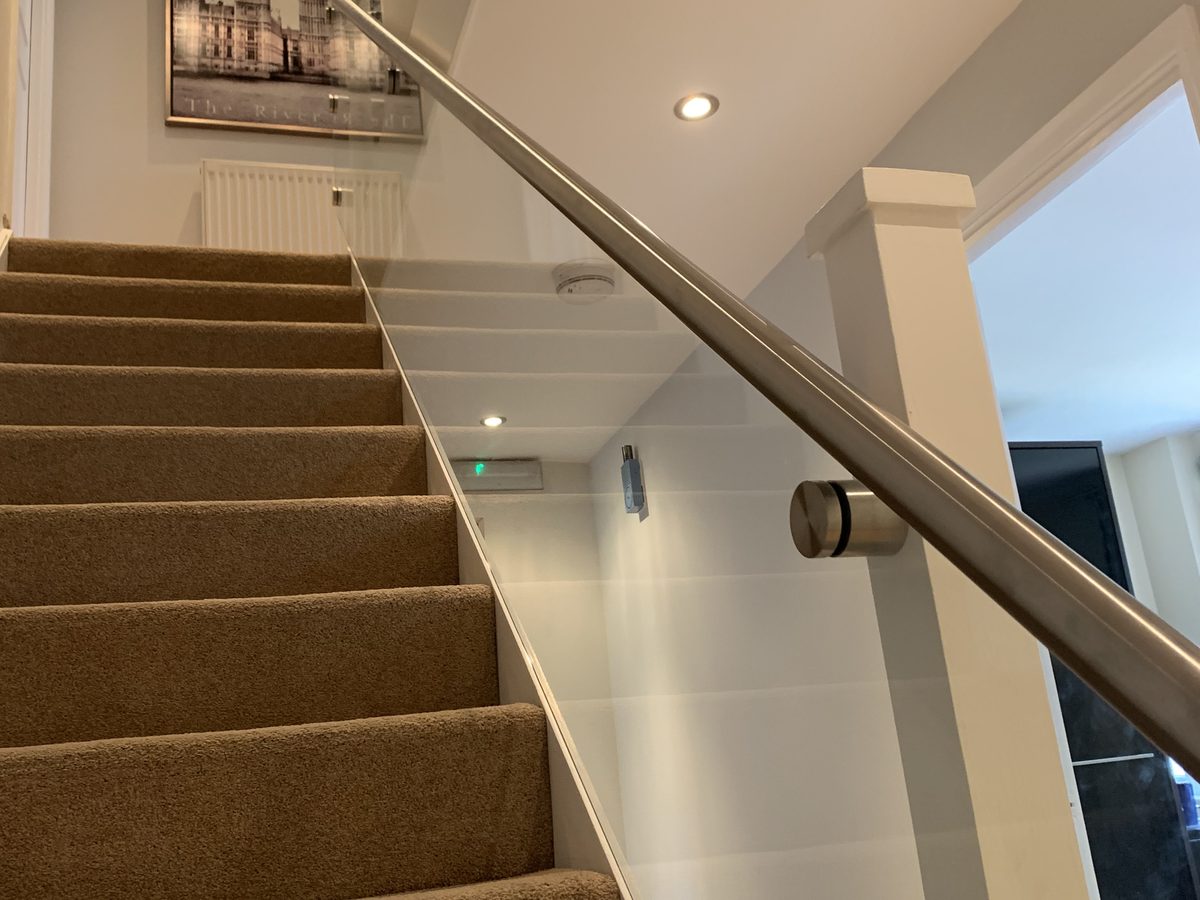 Glass staircase balustrade with a brushed stainless handrail