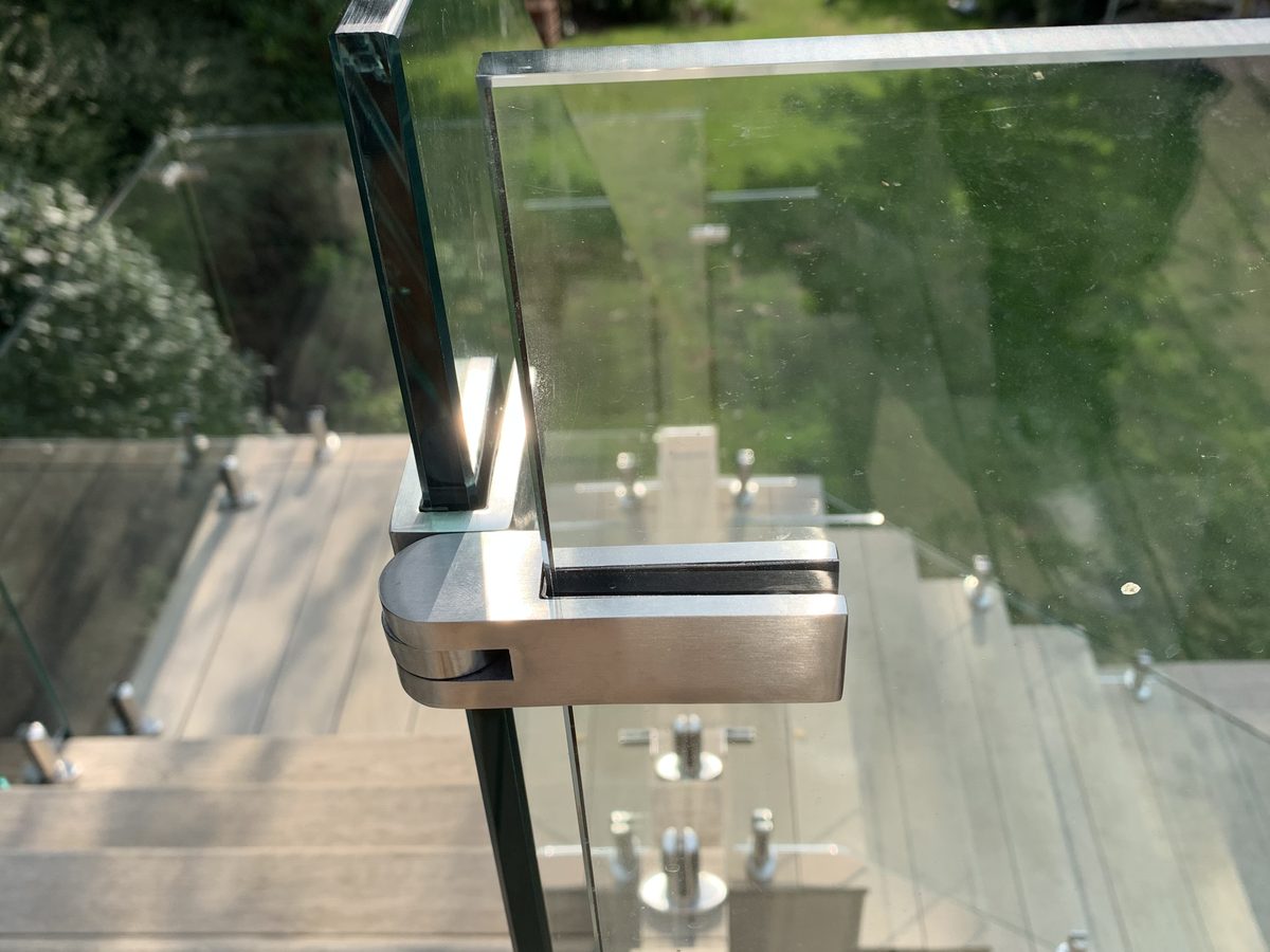 Stainless steel glass clamp on a balustrade post, close up